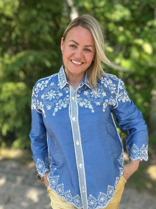 Zila blūze ar balti puķainiem ornamentiem