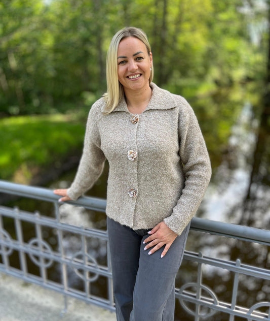 Īsa, smilškrāsas adīta jaciņa ar apkakli, aizdari rotā trīs dekoratīvas puķu formas pogas - DJE 019