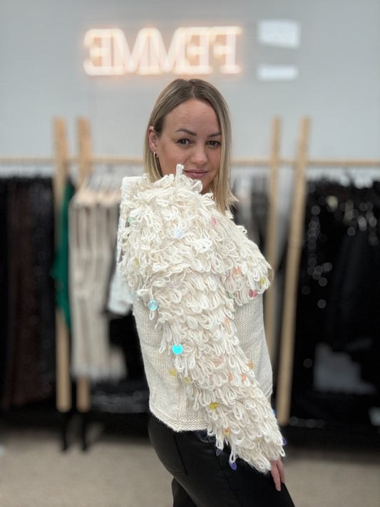 Piena balts džemperis ar cilpām un gliteriem.