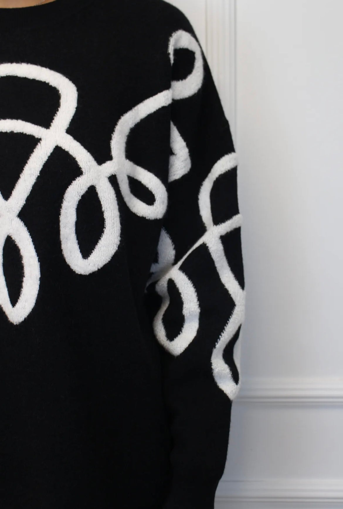 Melns kostīms ar baltiem izšuvumiem 