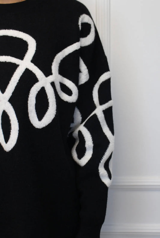 Melns kostīms ar baltiem izšuvumiem 