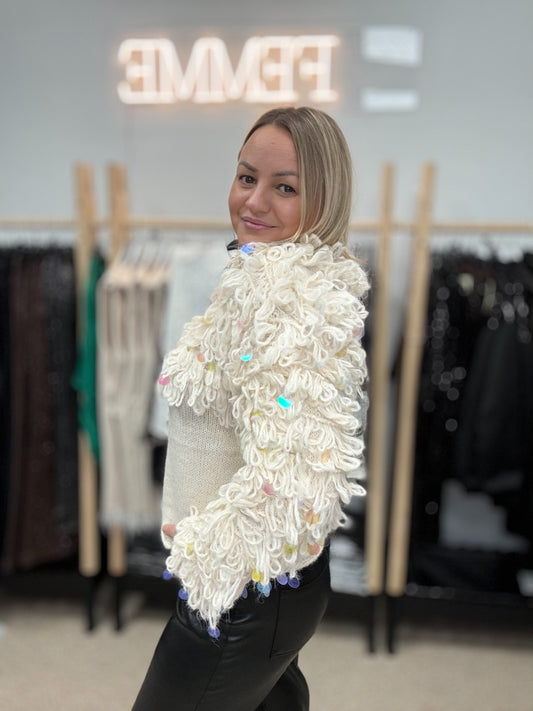 Piena balts džemperis ar cilpām un gliteriem.