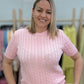 Розовый свитер с косами