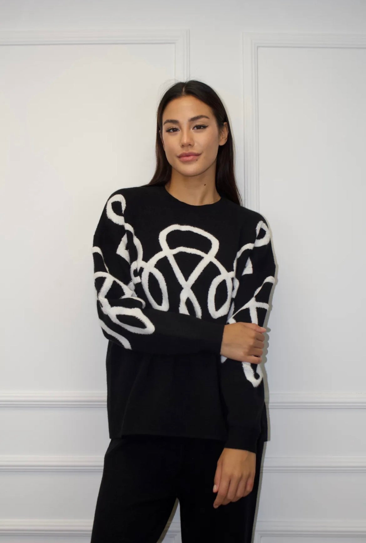 Melns kostīms ar baltiem izšuvumiem 